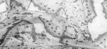 gray monochrome fabric with snakeskin pattern, background texture of bright gray fabric close up. background, texture, patternの写真素材