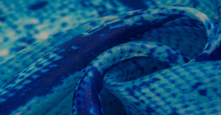 blue fabric with snakeskin pattern, background texture of bright blue fabric close up. background, texture, patternの写真素材
