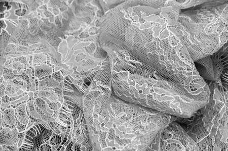 Gray-white lace on a black background. Template for wedding invitation and greeting card with lace fabric background. Filigree floral elements, ornate vintage ornament.の写真素材