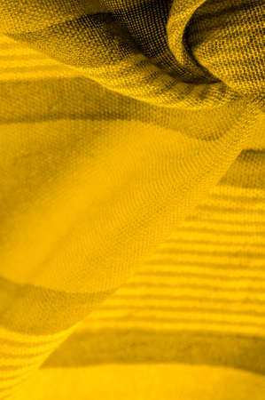 Silk fabric of yellow color, Texture. Background. of the color between green and orange in the spectrum, a primary subtractive color complementary to blue; colored like ripe lemons or egg yolks.の写真素材