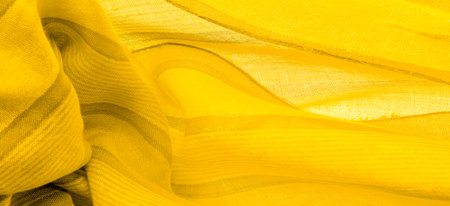 Silk fabric of yellow color, Texture. Background. of the color between green and orange in the...
