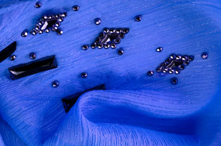 blue fabric with glued decorative faceted stones. texture background with bright colorful stones, texture background design Silk pattern,の写真素材