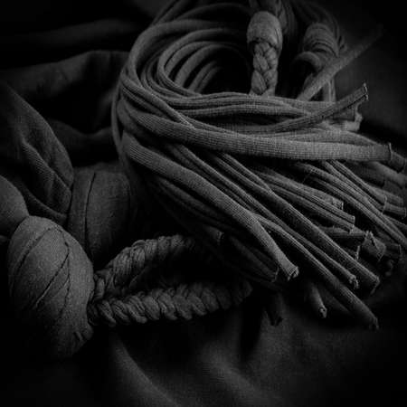 Fabric in black braids. Knitted knitted background with embossed pattern. Braids in knitting. Texture, backgroundの写真素材