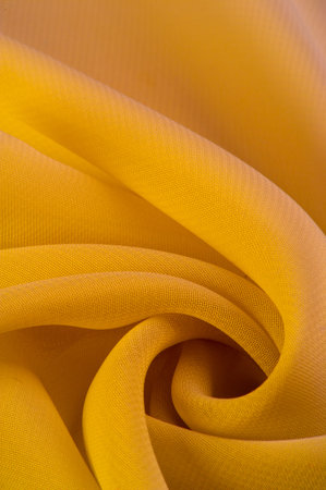 yellow silk polyester. Background from yellow silk fabric. Textured background made of transparent...