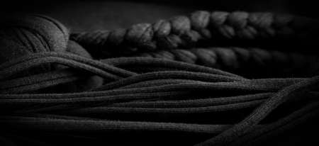 Fabric in black braids. Knitted knitted background with embossed pattern. Braids in knitting. Texture, backgroundの写真素材