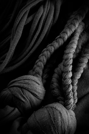 Fabric in black braids. Knitted knitted background with embossed pattern. Braids in knitting. Texture, backgroundの写真素材