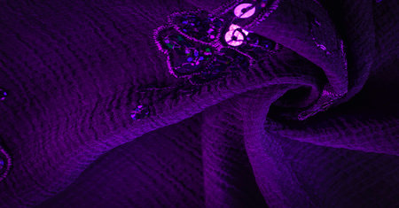 Silk blue. The fabric is embellished with sequins. background, silk satin, luxurious texture, dark...