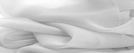 white silk polyester. Background from ghost white silk fabric. Textured background made of transparent and light fabric for sewing clothes. Textile panorama.Texture. template.の写真素材
