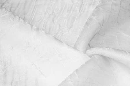 Silk fabric White. Dented and smoothed with traces of stripes. Texture background. Matte wedding satin fabric. These sophisticated lightweight stretch satin textiles create a stylish look.の写真素材