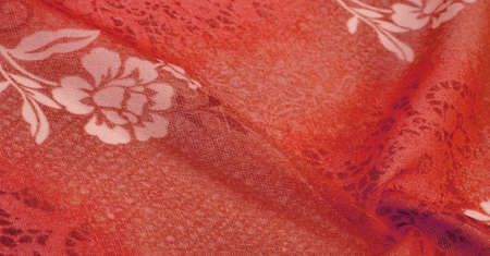 Red silk fabric with floral print. Clothing design. Modern floral background. Modern exotic jungle plants. Tinting, sunlight effect Texture, background, design.の写真素材
