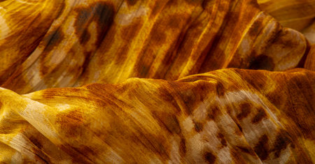 Silk fabric made of fine organza with print imitating panther skin, brown. Texture. Background....