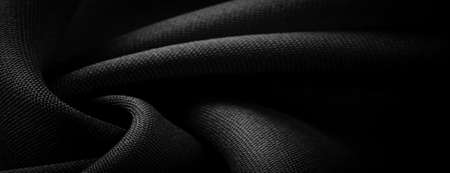 Satin Black Silk is a weave that usually has a glossy surface and a matte back, satin weave is characterized by four or more fillers or weft threads.の写真素材