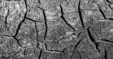 Old tarmac material. Applied to a metal surface. Cracks in resin evidence of time, grunge texture backgroundの写真素材