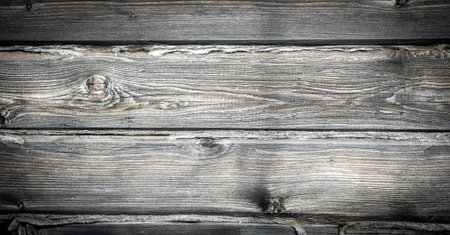 The texture of the old tree, the timber from which the house was built. Deep cracks are visible on...