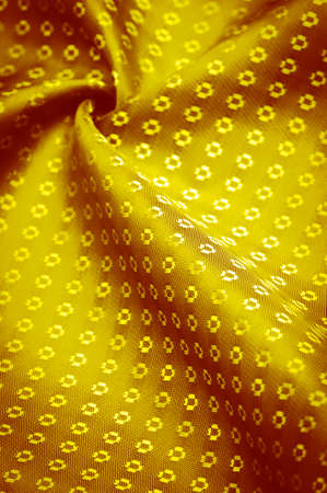 Silk fabric made of yellow gold, with small patterns of squares, rhombuses. Wealth and luxury in your design. Background texture, decorative ornamentの写真素材