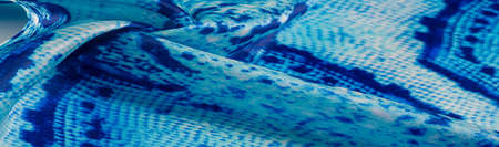 blue fabric with snakeskin pattern, background texture of bright blue fabric close up. background, texture, patternの写真素材