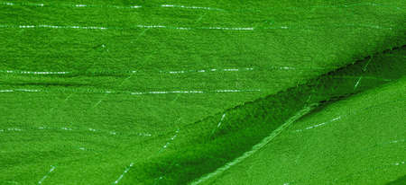 Green silk fabric with lurex. Glossy texture background, satin background, luxurious fabric, elegant pattern, colorful abstract, colorful velvet, shredded macro.の写真素材