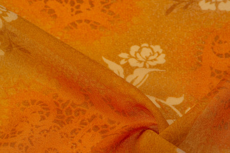 fabric, orange silk with a floral pattern. Fragment of colorful retro silk textile pattern with floral ornament used as background Texture, background, design,の写真素材