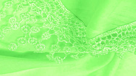 Spring green silk with lace capes. Smooth elegant green silk or luxe satin can be used as an abstract background. Background texture, postcard templateの写真素材