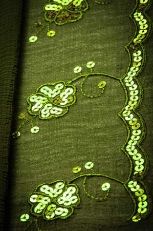 Silk green. The fabric is embellished with sequins. background, silk satin, luxurious texture, dark fabric, costume cotton material, abstract color image pattern, delicate liquid emerald velvetの写真素材