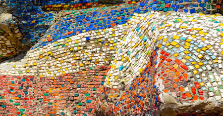 Old mosaic. Multi-colored shards of glass on a concrete surface. A pattern obtained by combining small colored pieces of a hard material such as stone, tiles, or glass.の写真素材