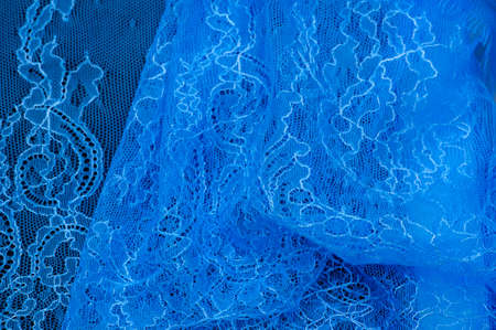 Blue lace on a black background. Template for wedding invitation and greeting card with lace fabric background. Filigree floral elements, ornate vintage ornament.の写真素材