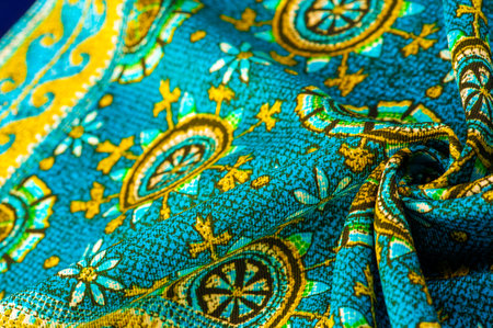 turquoise silk fabric with yellow drawings of flowers circles. Charmeuse has a beautiful drapery....