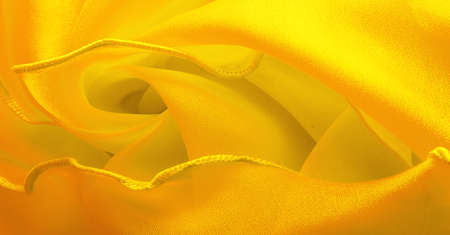 Yellow silk organza with wavy piping. Border around the edge of the fabric. Abstract background. texture pattern. Silk organza has a delicate open weave. Wave background. Copy spaceの写真素材