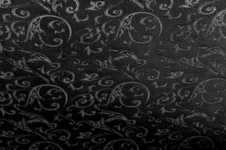 The texture of the fabric is black with a pattern of flowers.の写真素材