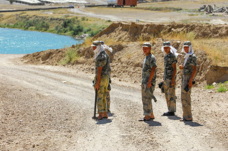 Indian army soldiers standing on a dirt road.