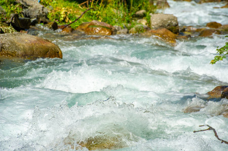 Immerse yourself in a symphony of nature with cascading mountain streams. Experience the mesmerizing melody created by the smooth and eternal stones. Dance among lush green landscapesの写真素材