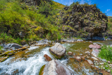 Enjoy the stunning beauty of nature's wonders. Watch the river flow gracefully through the rocky canyon. Venture into the heart of the mountains for truly spectacular views.の写真素材