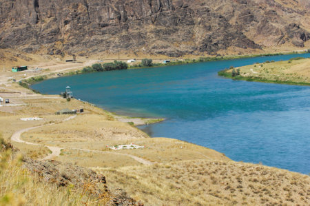 Feel the refreshing taste of summer water from the river. Enjoy the natural beauty of the river flowing through the steppe. Take a moment to relax and connect with nature on the rocky shores.の写真素材