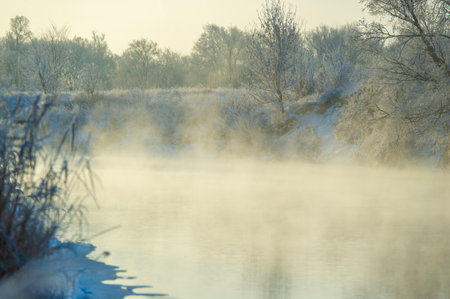 Experience the magic of a winter sunrise. Witness the breathtaking frozen beauty of nature. Capture the splendor of shimmering frost on a frozen river.の写真素材