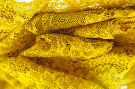 Yellow lace for lingerie and home decor Elastic textile jacquard lace adds beauty and functionality Versatile use as a decorative element. Rubber band or texture for designの写真素材