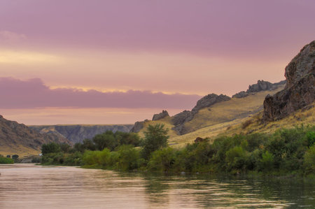 Enjoy the breathtaking beauty of the steppe. Discover hidden treasures such as stunning cliffs and winding rivers. Witness the dramatic hues of a sunset in the wild.の写真素材