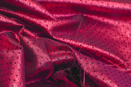 Fabric with a metallic sheen in small polka dots. Red burgundy.の写真素材