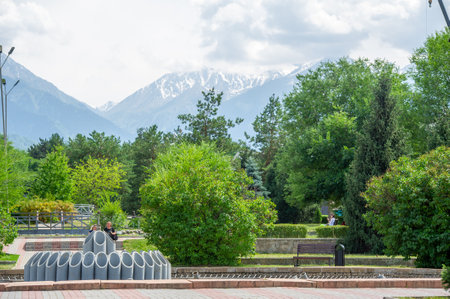 Serenity and Majesty: Travel along this scenic road surrounded by tall trees and majestic mountains. Let the serenity of nature embrace your senses and inspire your soul. Kazakhstan Almatyの写真素材