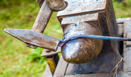 Blacksmithing is an art. Crushing a red-hot steel rod with a hammer or cutting into it with a chisel requires the participation of the entire physical being of a person.の写真素材