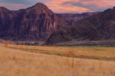 Enjoy the stunning beauty of the steppe landscape. Enjoy the vibrant sunset over the rugged cliffs. Enjoy the peace and tranquility of a calm river during your holiday in nature.の写真素材