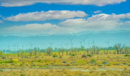 Elegant wind turbines standing against the backdrop of a picturesque sunset. A combination of...