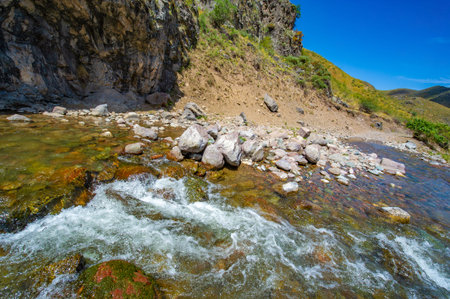 Enjoy the serene beauty of nature in the majestic rocky canyon. Watch the river gracefully flow...