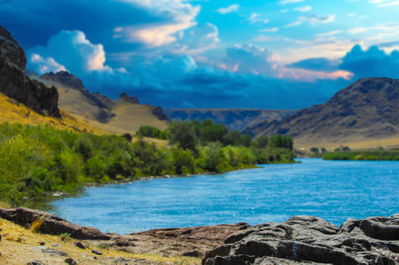 the breathtaking beauty of a serene sunset over the river. Relax and unwind in the tranquil surroundings of majestic mountains and lush green trees. Immerse yourself in the tranquility of natureの写真素材