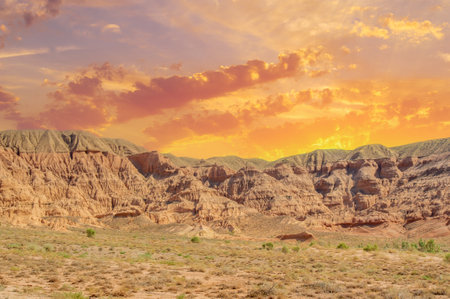 Experience the breathtaking beauty of the Red Boguty Mountains. Travel through this enchanting desert oasis. Let the fiery shades of the setting sun captivate your heart.の写真素材