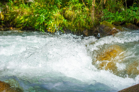 Immerse yourself in a symphony of nature with cascading mountain streams. Experience the mesmerizing melody created by the smooth and eternal stones. Dance among lush green landscapesの写真素材