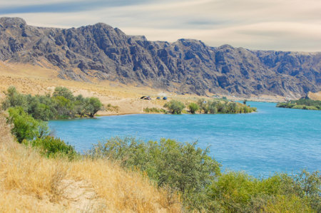 Enjoy the serene and breathtaking views of nature. Watch the sunset over the river. Creating a picturesque scene. Enjoy the tranquility of the mountains and trees surrounding the flowing river.の写真素材