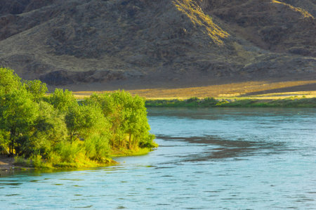 Explore the majestic beauty of the mountains in summer. Raft down a mighty river surrounded by stunning scenery. Experience the thrill of adventure while basking in the sun.の写真素材