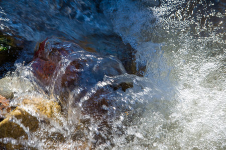 Serene waters flowing through rocky obstacles create a harmonious symphony of nature's resilience.