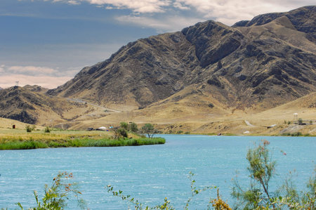 stunningly beautiful sunset over a calm river. Relax and unwind in the peaceful setting of majestic mountains and lush green trees. Connect with nature and find inner peace while admiring breathtakingの写真素材