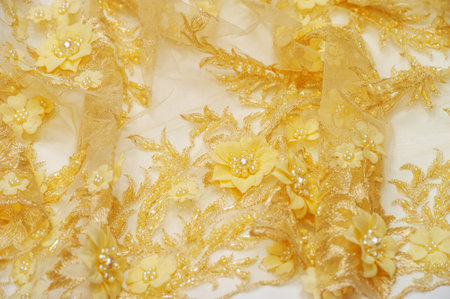 Golden yellow lace texture for various design projects. Can be used as a background for postcards. posters textures. and wallpaper A sample of the ancient lace pattern with intricate linesの写真素材